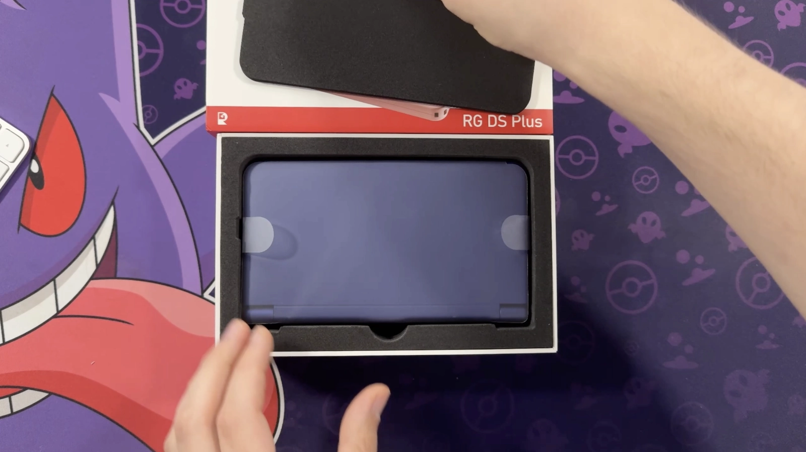 Der blaue Anbernic RG DS Plus liegt beim Unboxing noch in seiner geöffneten Verpackung.
